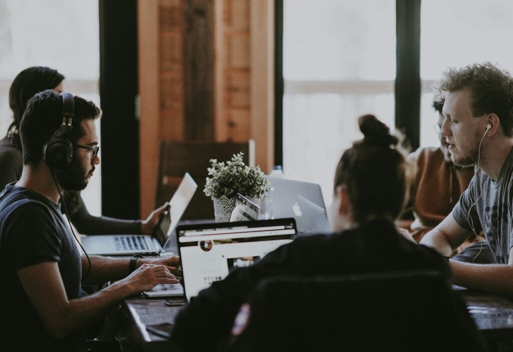 workers at table on laptops